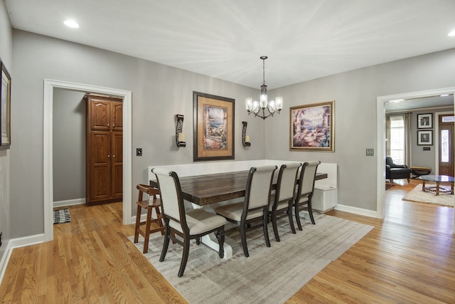 dining space with light wood-type flooring and a chandelier