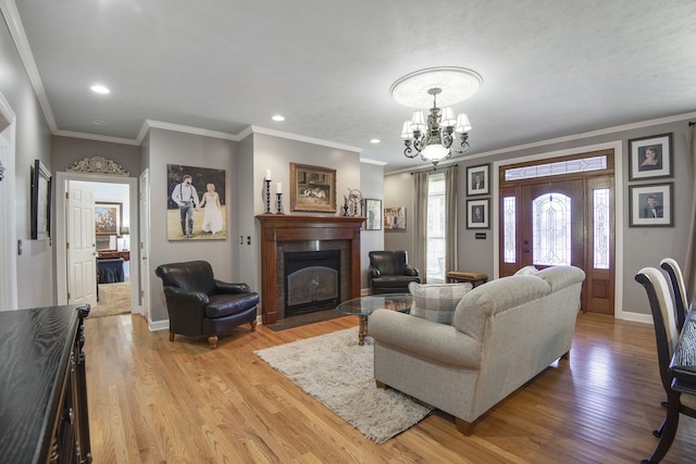 living room with light hardwood / wood-style floors, a chandelier, and ornamental molding