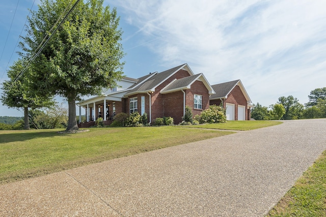 view of front of property with covered porch, a garage, and a front lawn