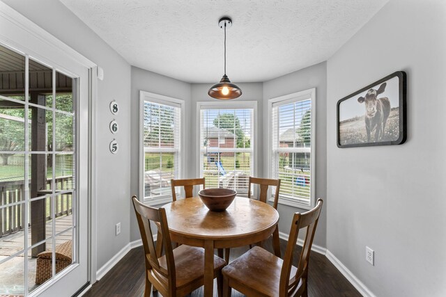 dining area featuring a textured ceiling and dark hardwood / wood-style floors