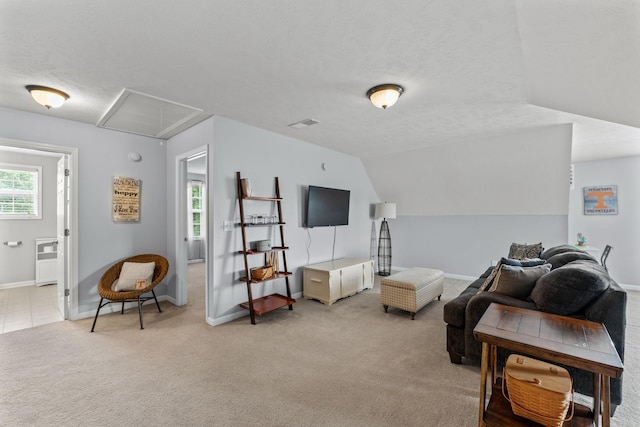 living room with lofted ceiling, light colored carpet, a textured ceiling, and baseboards