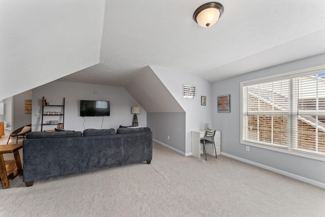 carpeted living room with vaulted ceiling and baseboards