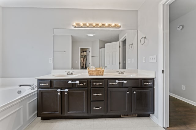 bathroom with hardwood / wood-style floors, a bathing tub, and vanity