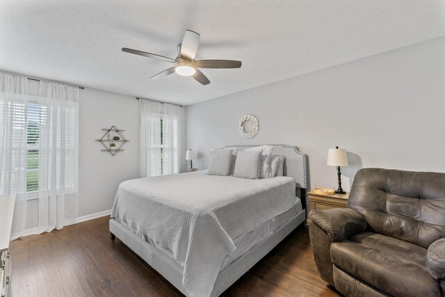 bedroom with ceiling fan, dark wood-type flooring, a textured ceiling, and baseboards