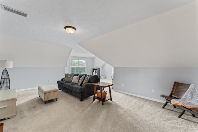 living room with a textured ceiling, lofted ceiling, and light carpet