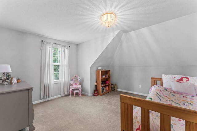 bedroom with a textured ceiling, light carpet, and lofted ceiling