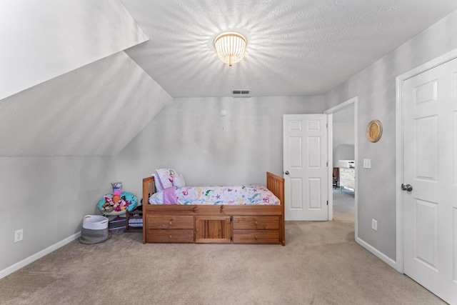 bedroom featuring light carpet, visible vents, vaulted ceiling, and a textured ceiling