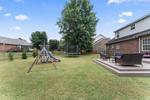 view of yard featuring a trampoline, a deck, outdoor lounge area, and a playground