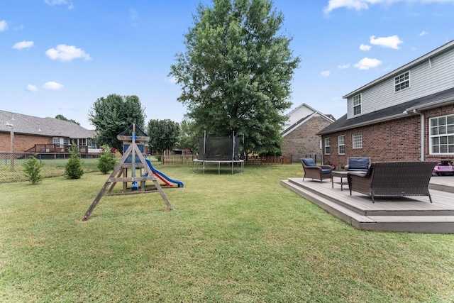 view of yard featuring a trampoline, a playground, outdoor lounge area, fence, and a wooden deck