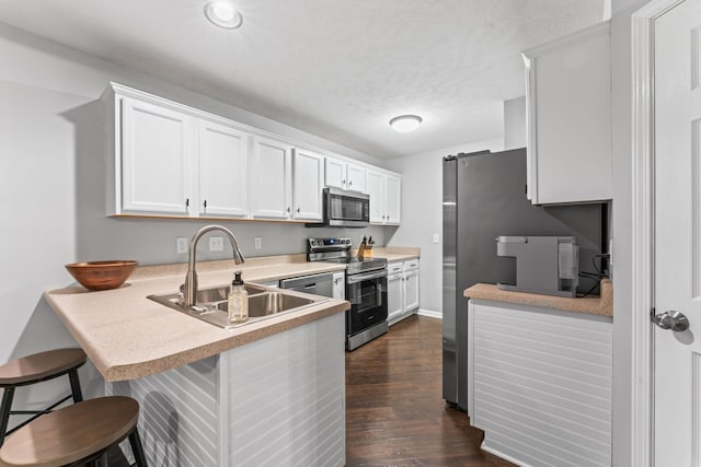 kitchen with white cabinetry, appliances with stainless steel finishes, light countertops, and a sink