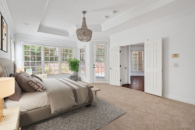 bedroom with multiple windows, a raised ceiling, and dark carpet