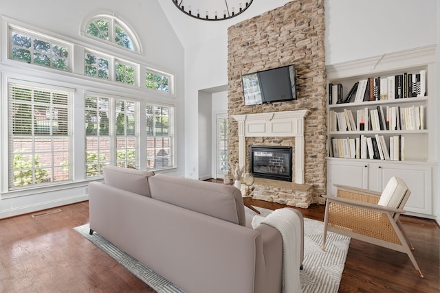 living room with a fireplace, high vaulted ceiling, dark wood-type flooring, and built in shelves