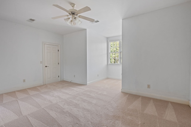 carpeted spare room with ceiling fan