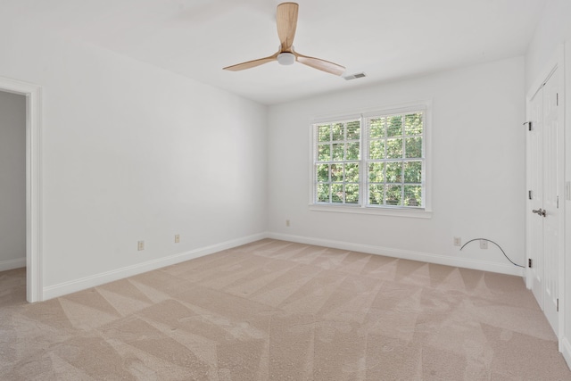 carpeted spare room featuring ceiling fan