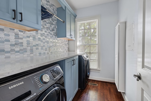 washroom with dark wood-type flooring, washer / dryer, and cabinets