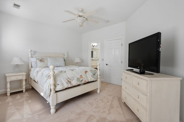 carpeted bedroom featuring ceiling fan and ensuite bath