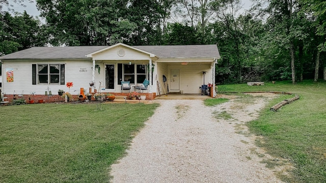 ranch-style home with gravel driveway, a front lawn, an attached carport, and covered porch