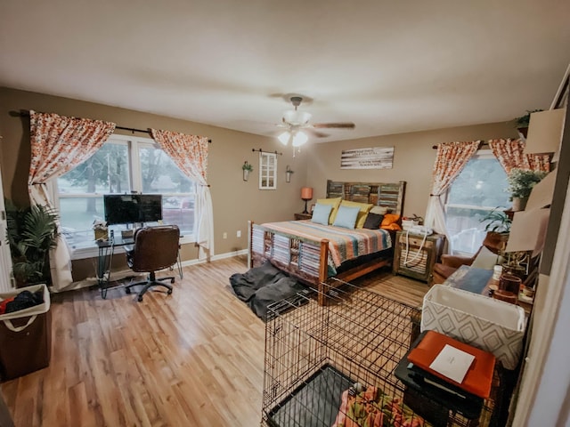 bedroom featuring baseboards, wood finished floors, and a ceiling fan