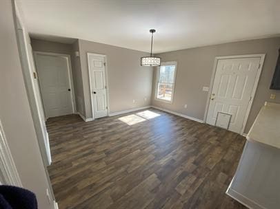 unfurnished dining area featuring dark hardwood / wood-style floors and an inviting chandelier