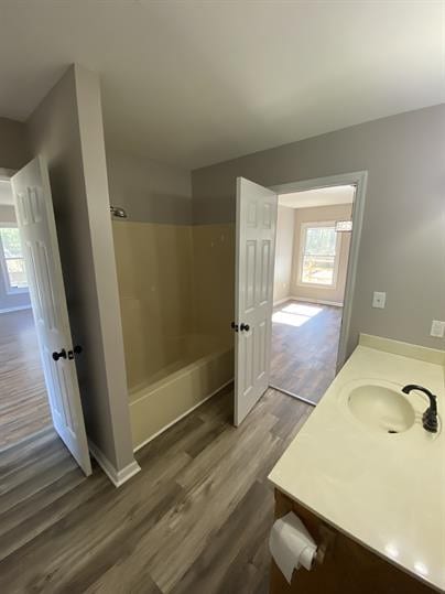 bathroom with  shower combination, hardwood / wood-style flooring, and vanity