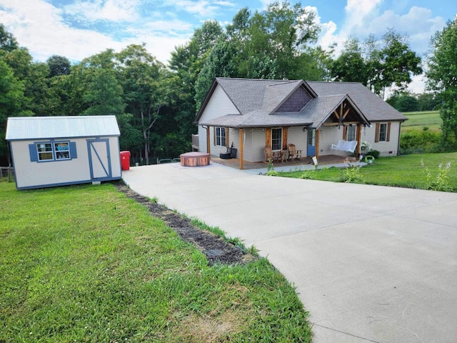 view of front of property featuring a front lawn, covered porch, and an outdoor structure