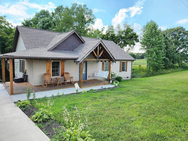 view of front of property with a shingled roof, a front lawn, and a porch