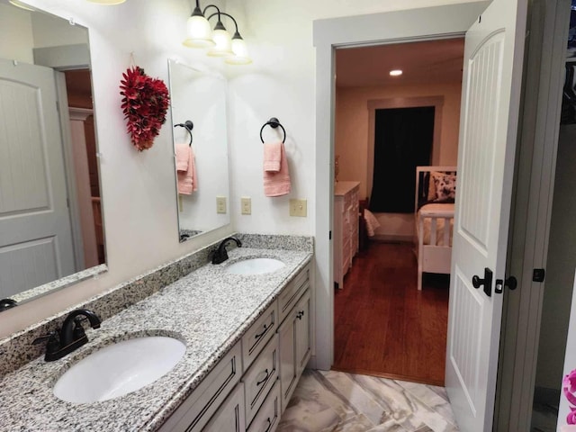 full bath featuring double vanity, a sink, and a notable chandelier