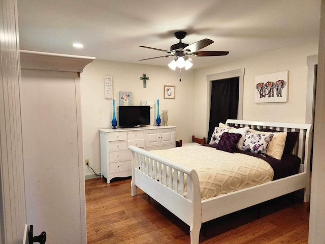 bedroom with ceiling fan and dark hardwood / wood-style flooring