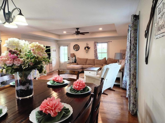 dining area featuring ceiling fan, dark hardwood / wood-style floors, and a raised ceiling