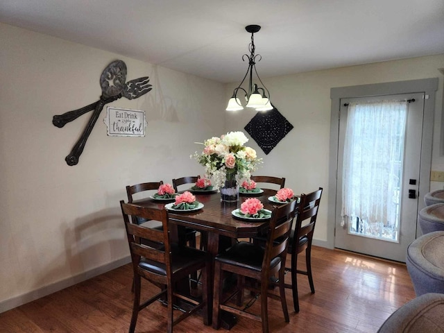 dining area with baseboards and wood finished floors