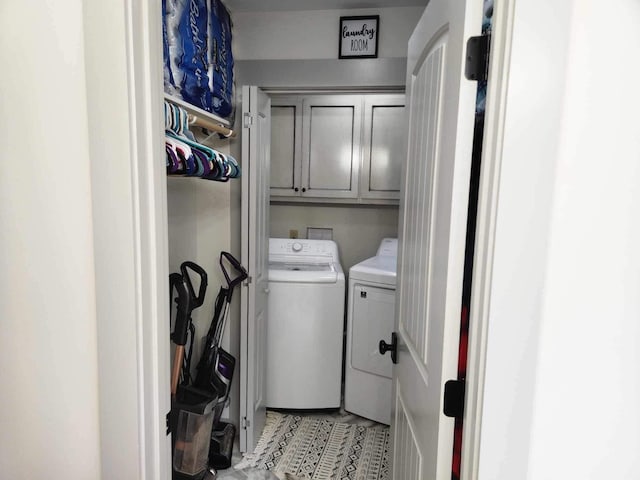 washroom with cabinet space and separate washer and dryer