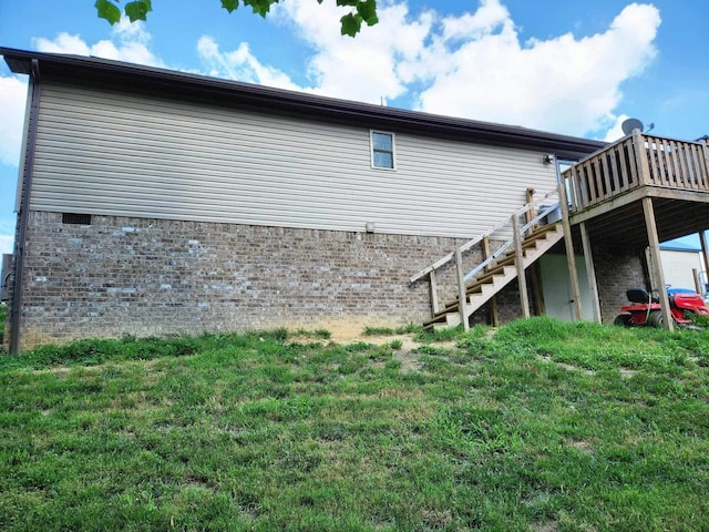 view of property exterior with stairs, a deck, and a yard