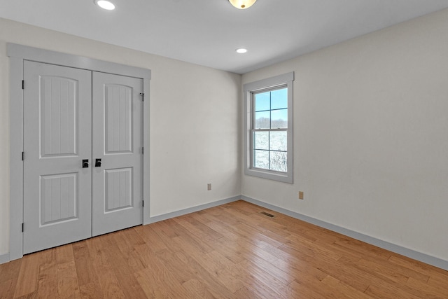 unfurnished bedroom featuring a closet and light hardwood / wood-style floors