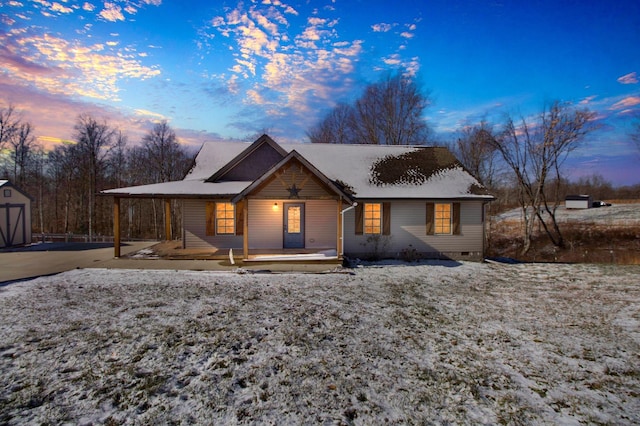 view of front of property featuring a porch, crawl space, an outdoor structure, and a storage shed