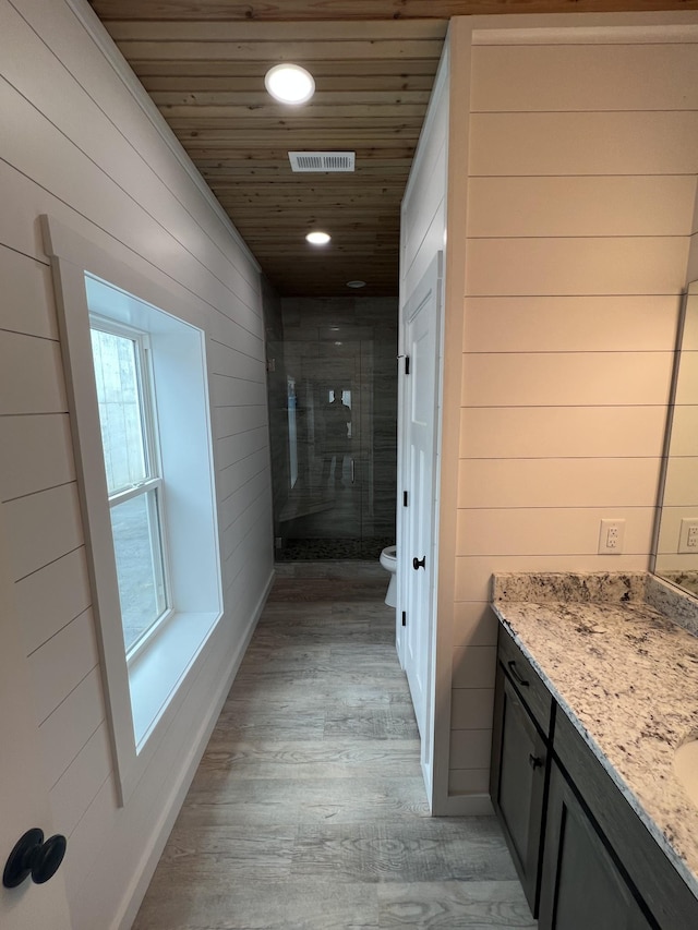 full bathroom featuring vanity, wood finished floors, visible vents, a shower stall, and wood ceiling