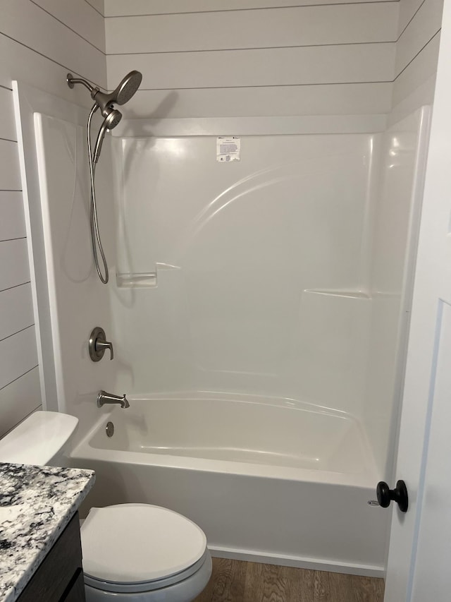 bathroom with toilet, tub / shower combination, vanity, and wood finished floors