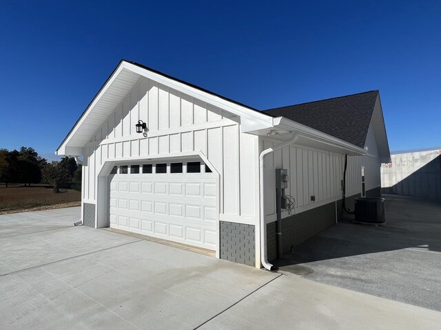 view of property exterior with central air condition unit and a garage