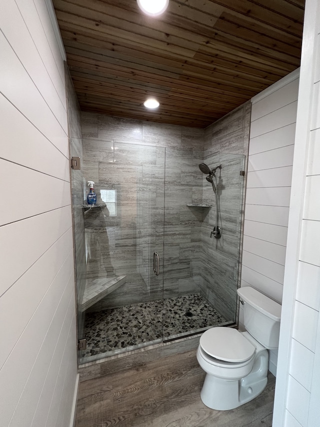 bathroom with hardwood / wood-style flooring, wood ceiling, toilet, and a shower with door