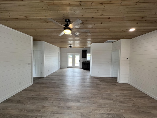 unfurnished living room featuring wood finished floors, wooden ceiling, a ceiling fan, and wood walls