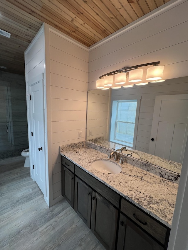 full bathroom with vanity, wood finished floors, a shower stall, wooden ceiling, and toilet