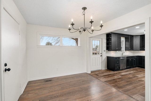 unfurnished dining area featuring dark hardwood / wood-style flooring, sink, and a chandelier