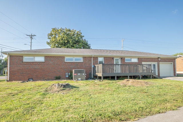 ranch-style home featuring a wooden deck, cooling unit, a garage, and a front yard