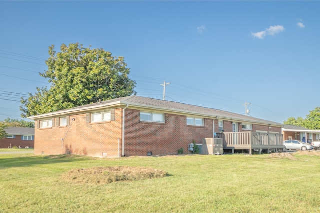 rear view of house featuring a yard and a wooden deck