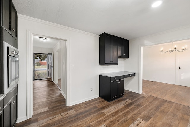 kitchen with decorative backsplash, ornamental molding, a chandelier, and dark hardwood / wood-style floors