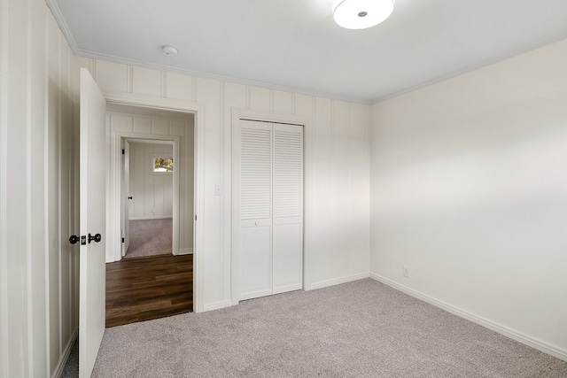 unfurnished bedroom featuring carpet, ornamental molding, and a closet