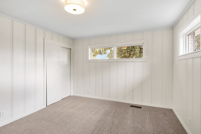 unfurnished room with a wealth of natural light and light colored carpet