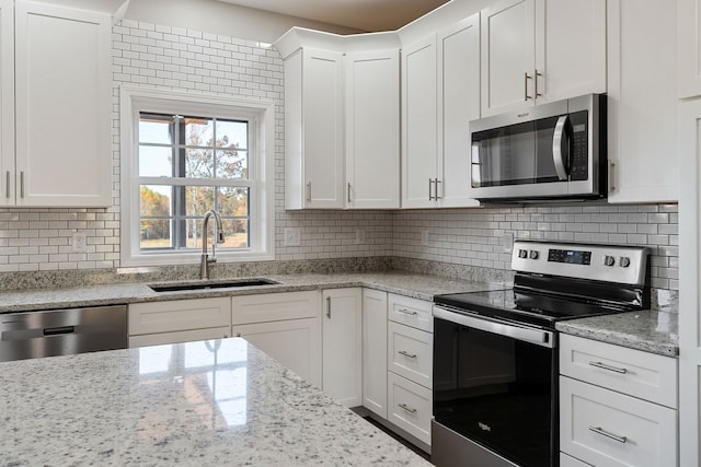 kitchen with white cabinetry, stainless steel appliances, and sink