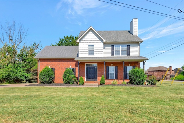 view of front of house with a front yard, brick siding, a chimney, and a shingled roof