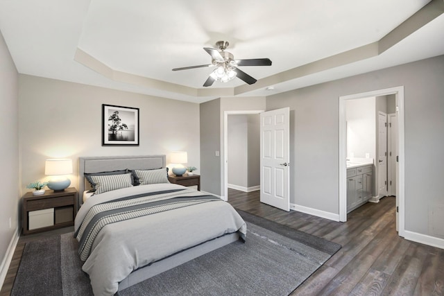 bedroom with a ceiling fan, ensuite bath, dark wood-style floors, and baseboards