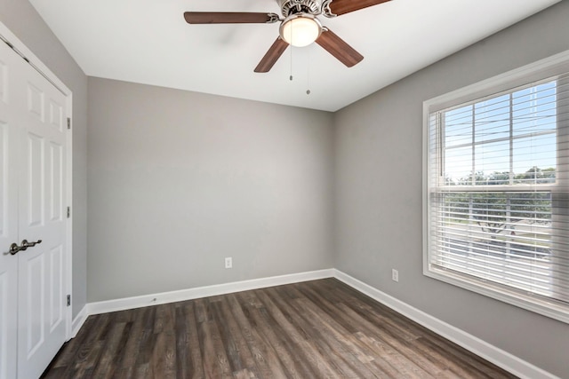 unfurnished bedroom with baseboards, dark wood-type flooring, and a ceiling fan